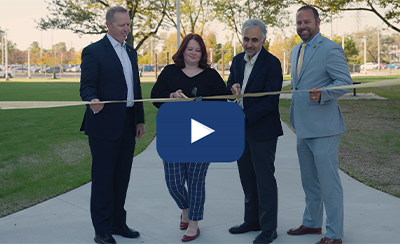 UToledo leadership cutting ribbon with large scissors